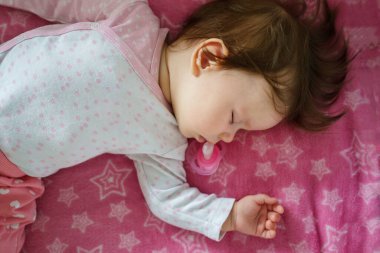 Kafkasyalı küçük bir kız. Beş aylık. Beşiğinde uyuyor.