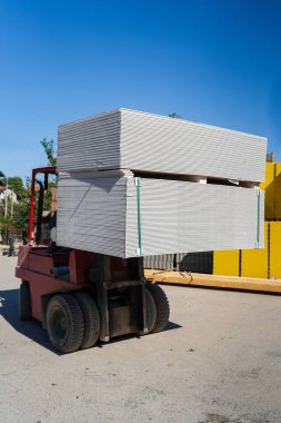 Çatal kaldırıcıyı kapat, alçıpan yığınını palette taşı.