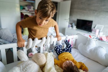 Küçük beyaz bir çocuk 5 yıl boyunca küçük kardeşleriyle oynamış. Beşiğe bakmış. Gerçek insanlara.