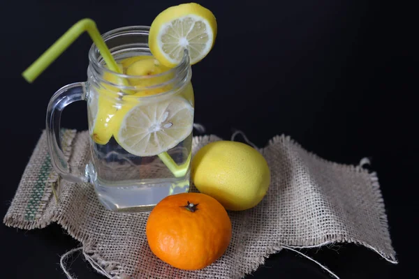 Lemonad Glasburk Med Skivade Citronskivor Och Ett Dricksrör Ett Dekorerat — Stockfoto