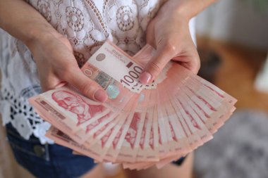 Bir yığın parayı tutan kadın elleri. Sırp dinar kağıt para birimi, 1000 dinar değerinde