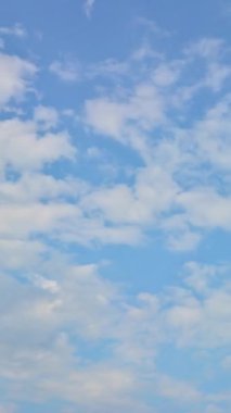 Beautiful clouds on the blue sky on a summer day. Weather concept footage. Copy space for design. The vertical position of the time lapse video