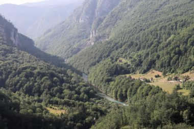 Tara Nehri Kanyonu, Karadağ - 17 Temmuz 2021 Karadağ 'daki Curdjevica Tara köprüsünden güzel mavi nehir ve köy manzarası