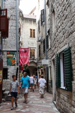 Kotor, Karadağ - 20 Temmuz 2021 Dar Sokak, Kotor 'daki eski şehrin yaz gününde taş cepheleriyle yürümek için kaldırım taşı döşedi