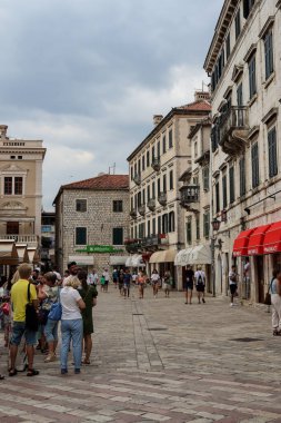 Kotor, Karadağ - 20 Temmuz 2021 Kotor 'daki sıcak yaz gününde eski kasabadaki taş binaların cepheleriyle yürümek için Paved Caddesi