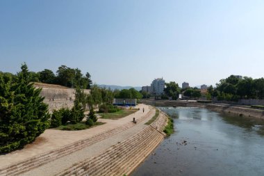 Nis, Sırbistan - 14 Ağustos 2021 Nisava nehri güneşli yaz gününde Nis şehrinde güzel bir park rıhtımı ile