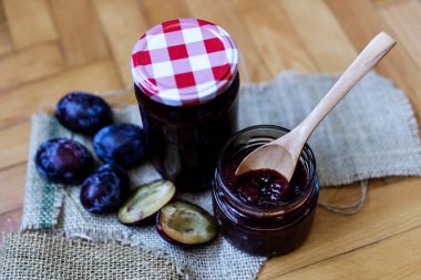 Masadaki erik reçeli dolu kavanozda tahta retro kaşık. Kapat, seçici odaklan ve boşluğu kopyala