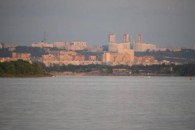 Büyük şehrin manzarası, sabah güneşiyle aydınlanan büyük nehrin karşısında..