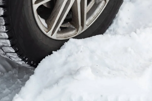 Off road winter tire packed with snow in deep snow. Closeup. Outdoor