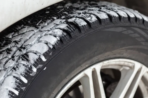 Off road winter tire packed with snow in deep snow. Closeup. Outdoor