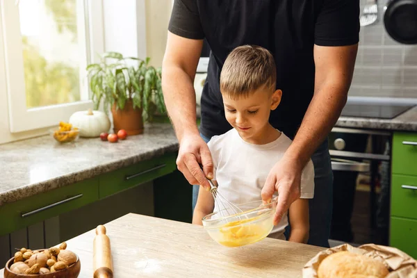 Caring father teaches his son to cook, indoor activity. Great time with family