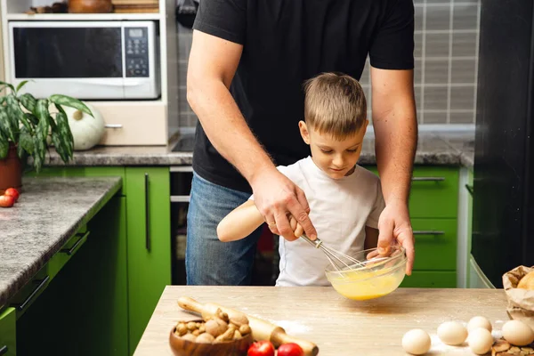 Caring father teaches his son to cook, indoor activity. Great time with family