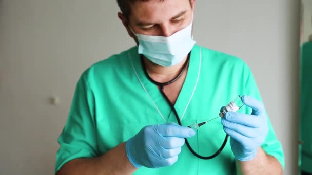 Lekarz w niebieskich rękawiczkach chirurgicznych umieszcza szczepionkę przeciw koronawirusowi w strzykawce, aby zaszczepić się przeciwko światowemu epidemicznemu koronawirusowi covid-19. Opieka zdrowotna i koncepcja medyczna — Wideo stockowe