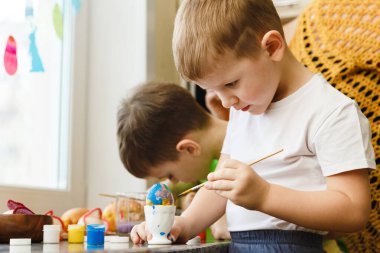 Evde Paskalya yumurtası ve tatil süslemeleri boyayarak iki çocuk Paskalya hazırlığı