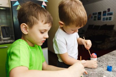 Evde Paskalya yumurtası ve tatil süslemeleri boyayarak iki çocuk Paskalya hazırlığı