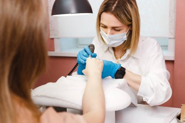 Güzellik salonunda manikür yaptıran genç bir kadın. Manikür, güzellik prosedürleri ve kişisel bakım. Portre