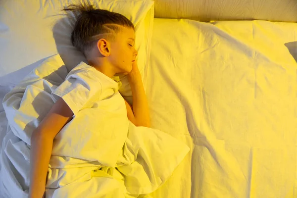 Aranyos Kisfiú Alszik Kényelmes Ágyában Reggel Sárga Napfény Alatt Reggelt — Stock Fotó