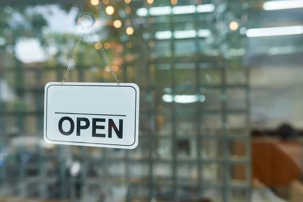 Sign on the glass door of the clothing store - (open) with free space for writing.