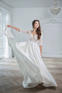 Güzel makyajlı, saç stili ve stüdyo fotoğraflı şık bir gelinlik giymiş genç bir gelinin portresi. Genç, çekici bir model.