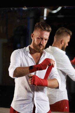 Gömlekli şık bir adam boks yapıyor. Aynadaki yansımaya bak.