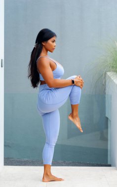 Atletik Asyalı kız antrenmandan önce ısınıyor. Fitness modeli turkuaz duvar arka grubuna karşı evde egzersiz yapıyor