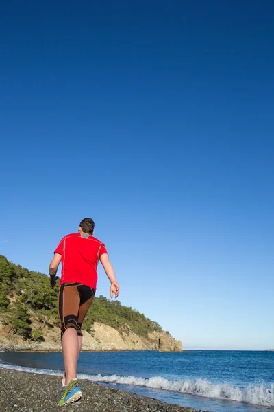 Corsa in montagna.L'uomo corre su una strada rurale durante il tramonto in montagna — Foto Stock
