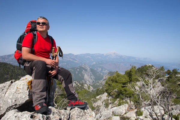 Stojąc na szczycie góry z doliny na tle wycieczkowicz. — Zdjęcie stockowe