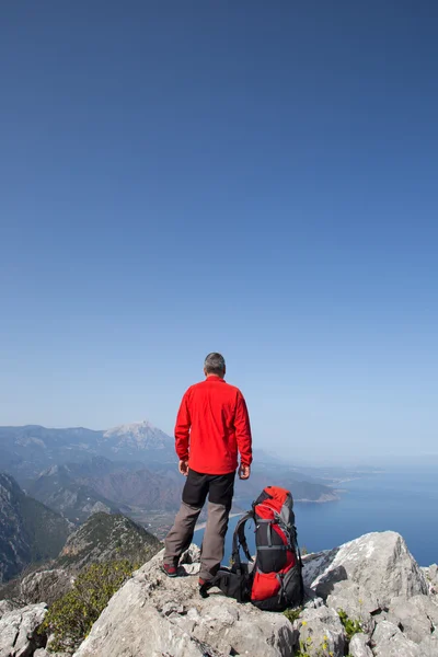 Hiker står på toppen av berget med dalen i bakgrunden. — Stockfoto