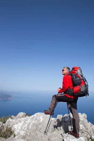 Wandelaar permanent op de top van de berg met vallei op de achtergrond. — Stockfoto