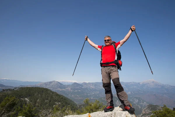 Turista stojí na vrcholu hory s údolím na pozadí. — Stock fotografie