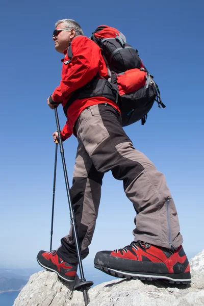 Caminante de pie en la cima de la montaña con el valle en el fondo . — Foto de Stock