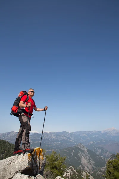 Escursionista in piedi sulla cima della montagna con valle sullo sfondo . — Foto Stock