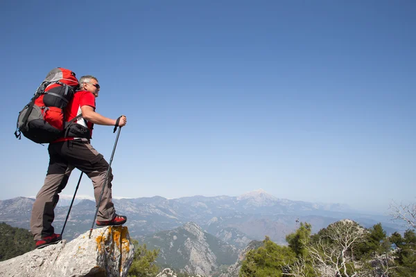 Escursionista in piedi sulla cima della montagna con valle sullo sfondo . — Foto Stock