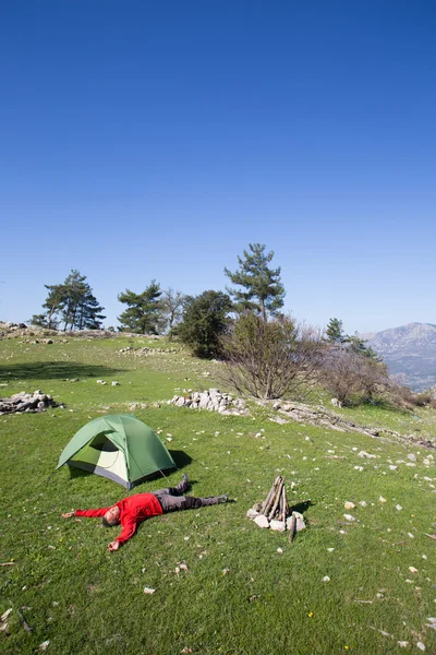 Turista stojí na vrcholu hory s údolím na pozadí. — Stock fotografie