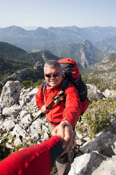 Istruttore di montagna ha dato a qualcuno una mano sulla cima della montagna — Foto Stock