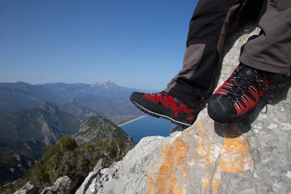 Hiker står på toppen av berget med dalen i bakgrunden. — Stockfoto