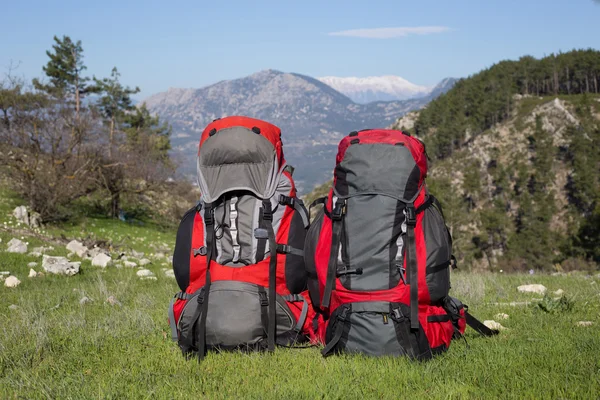 Red backpack standing on top of the mountain. — Stock Photo, Image