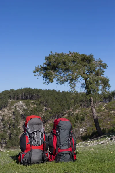 Červený batoh stojící na vrcholu hory. — Stock fotografie