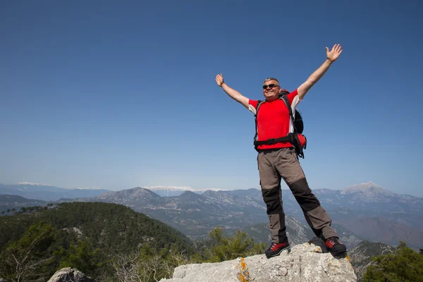 Turista stojí na vrcholu hory s údolím na pozadí. — Stock fotografie