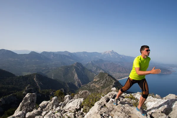 Trail runner entrenamiento cardio correr en las montañas rocosas camino de arena amarilla en la naturaleza . — Foto de Stock