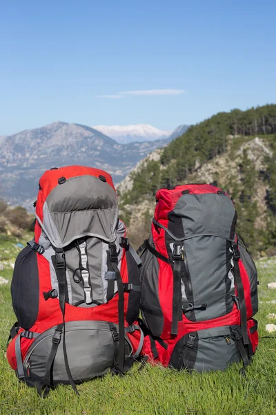Plecak stojący na szczycie góry na tle zaśnieżonych gór. — Zdjęcie stockowe
