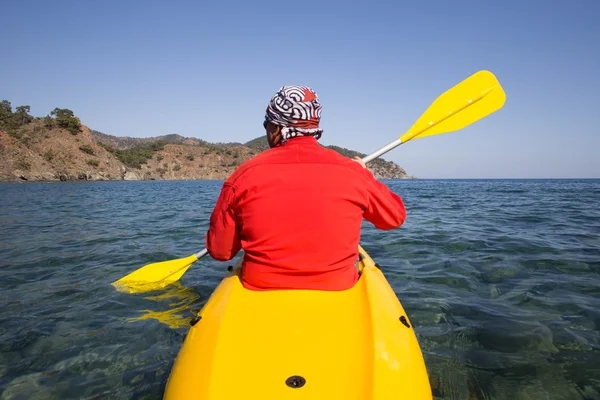 Ung kaukasisk man kajakpaddling i havet på Maldiverna. — Stockfoto