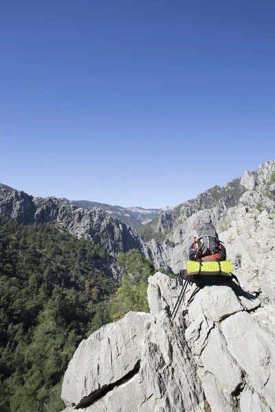 Σακίδιο στέκεται στην κορυφή ενός βουνού. — Φωτογραφία Αρχείου