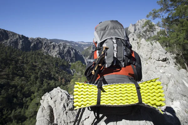 Bir dağın tepesinde duran sırt çantası. — Stok fotoğraf