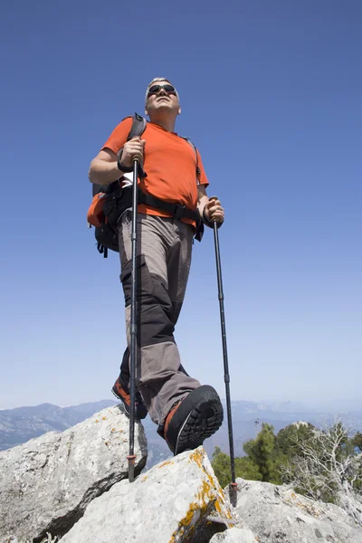 Een reiziger staat op de top van een berg en kijkt uit naar zee. — Stockfoto