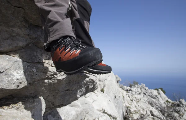 A traveler stands on top of a mountain and looks out to sea. — Stock Photo, Image