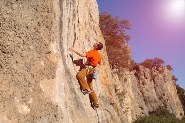Junger männlicher Kletterer hängt an einer Klippe. — Stockfoto