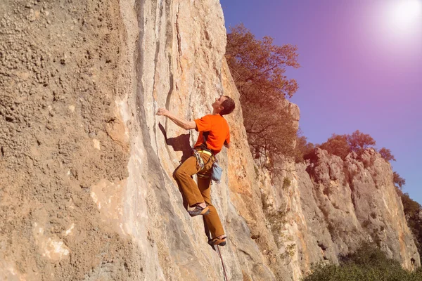 Giovane arrampicatore maschio appeso a una scogliera. — Foto Stock