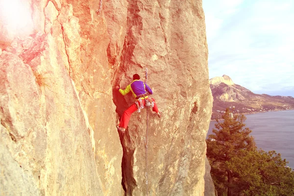 Uçurumun kenarında asılı genç bir tırmanıcı.