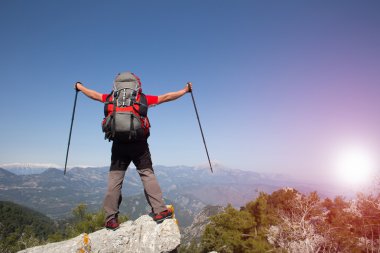 Gezgin bir dağın tepesinde güneş doğarken görünüyor. Dawn dağlarda.